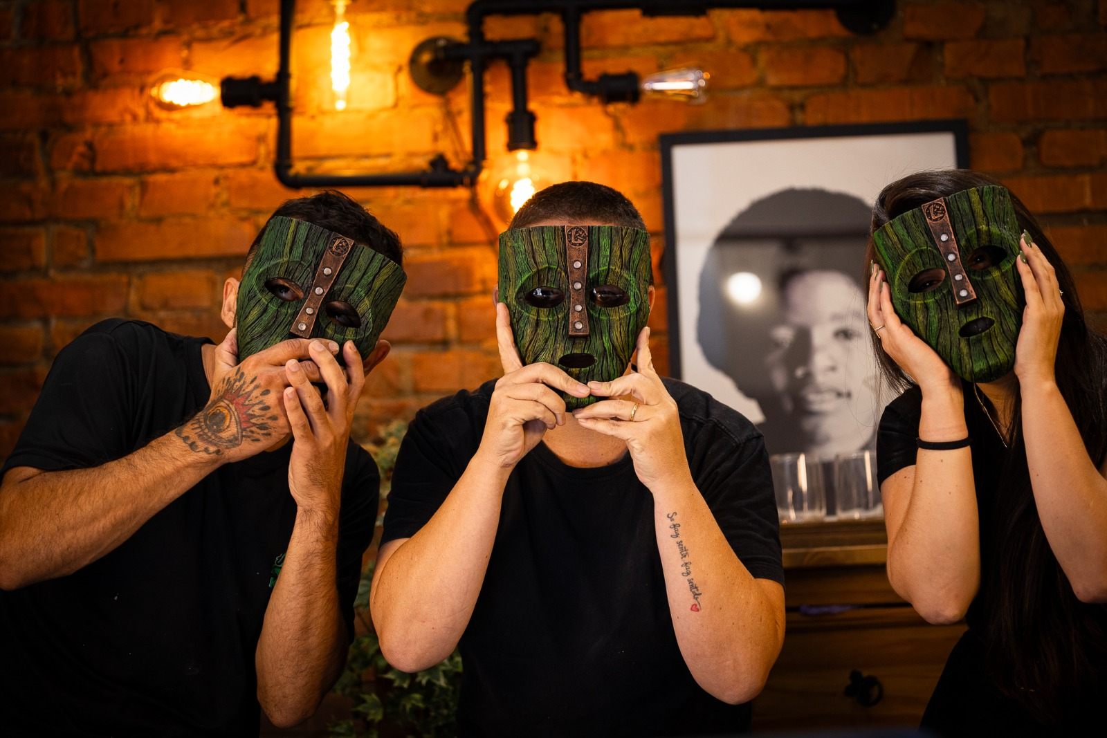 Três pessoas do time Kraken vestindo as máscaras pintadas à mão